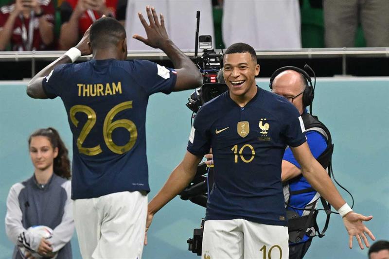 يحتفل المهاجم الفرنسي كيليان مبابي مع زميله ماركوس تورام بعد تسجيله الهدف الثالث لفريقه خلال بولندا فى كأس العالم قطر 2022.